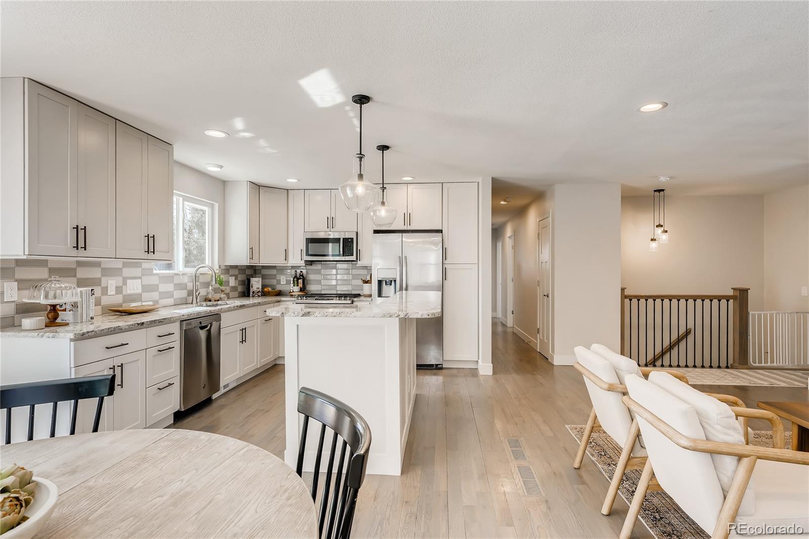 3530 East Orchard Road Centennial, CO 80121 - Photo 7 of 35 a kitchen with white cabinets and stainless steel appliances