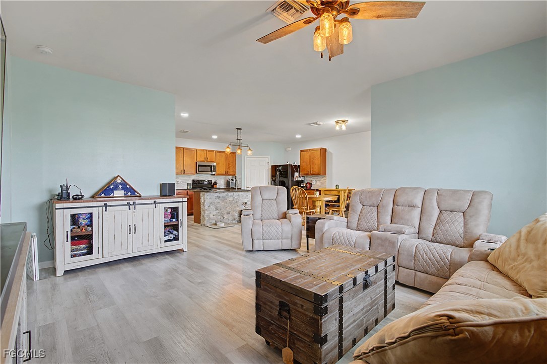 2613 Manzilla Lane Cape Coral, FL 33909 - Photo 11 of 42 a living room with furniture and a flat screen tv