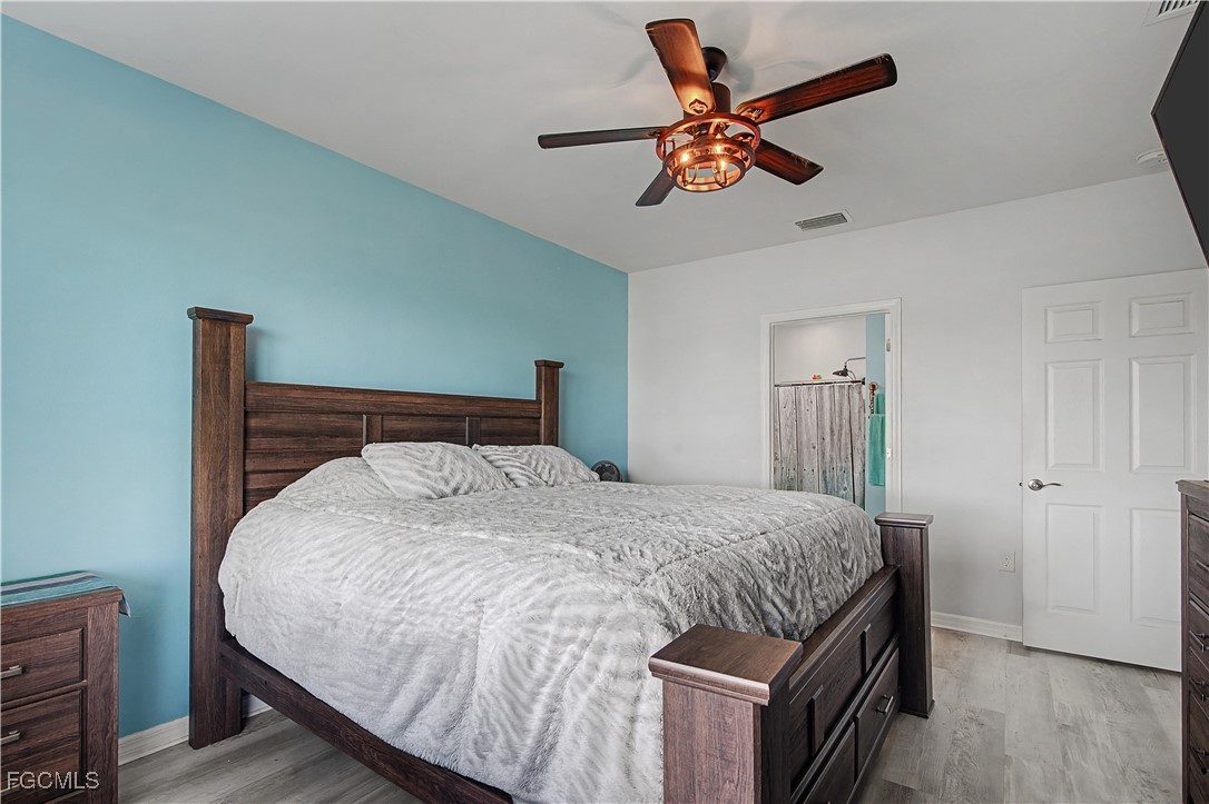 2613 Manzilla Lane Cape Coral, FL 33909 - Photo 14 of 42 a bedroom with a bed and a ceiling fan