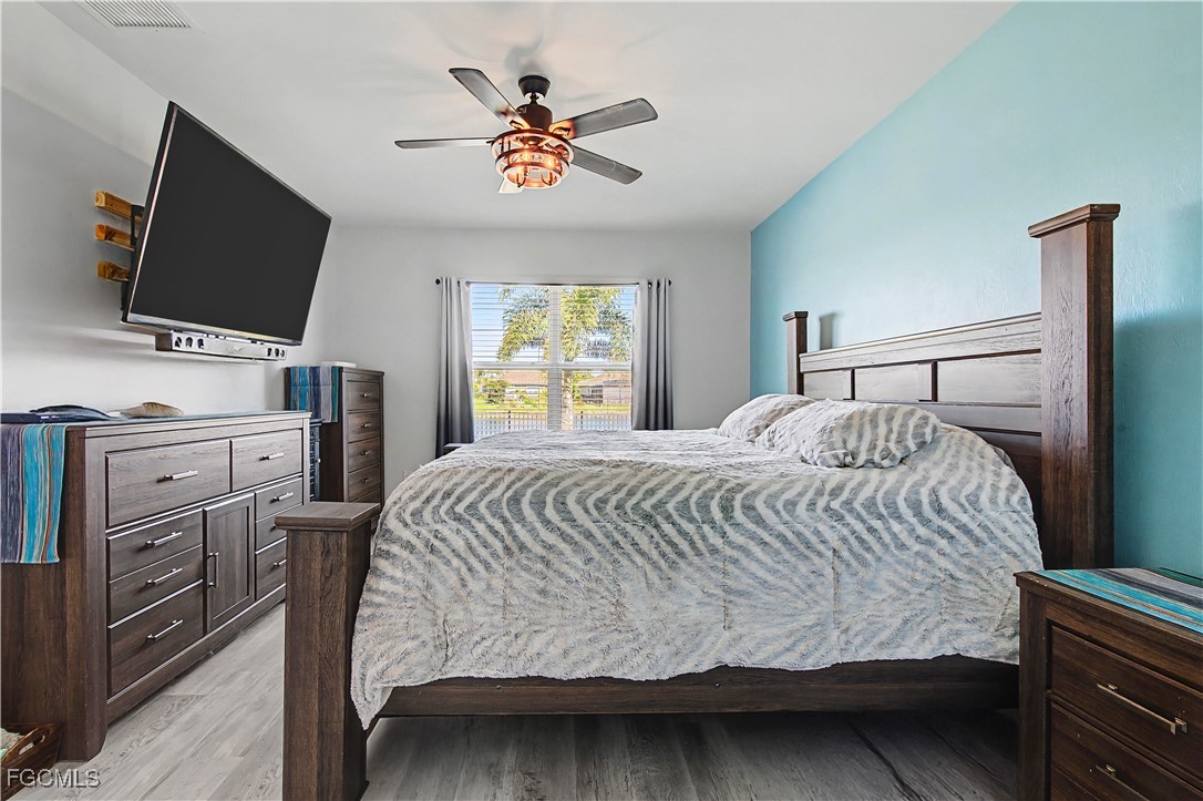 2613 Manzilla Lane Cape Coral, FL 33909 - Photo 15 of 42 a bedroom with a bed and a flat screen tv
