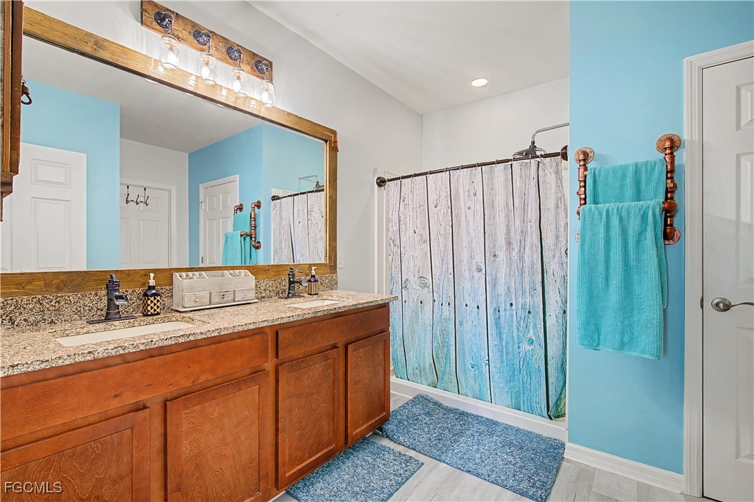 2613 Manzilla Lane Cape Coral, FL 33909 - Photo 16 of 42 a bathroom with a granite countertop sink and a mirror