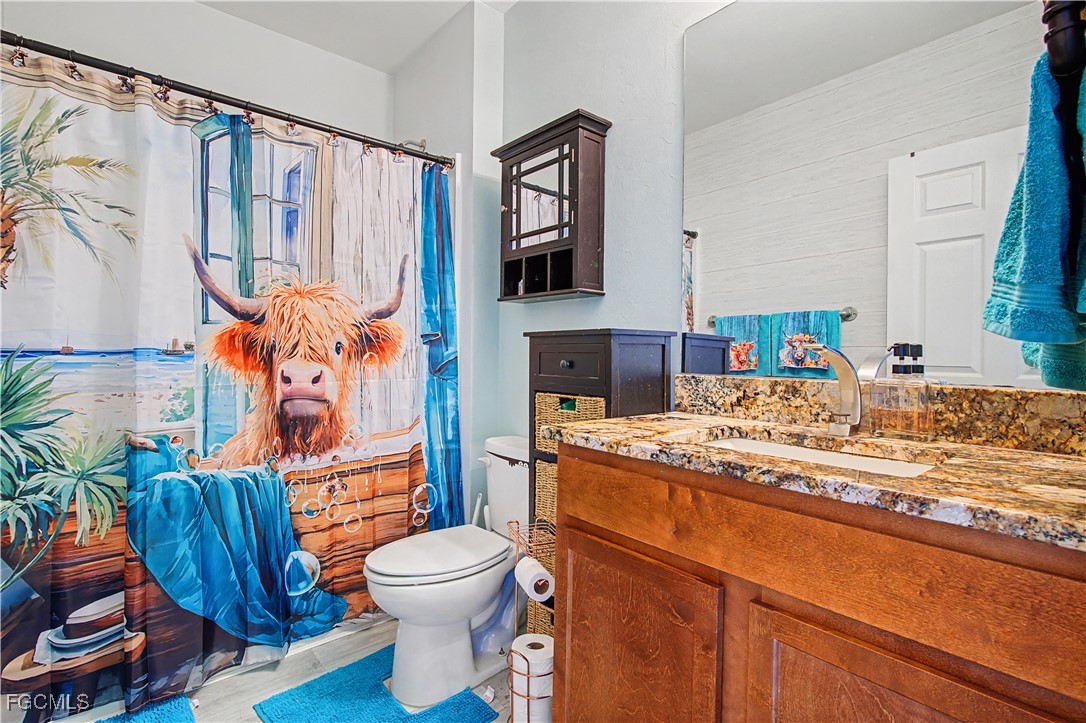 2613 Manzilla Lane Cape Coral, FL 33909 - Photo 18 of 42 a bathroom with a granite countertop toilet sink and mirror