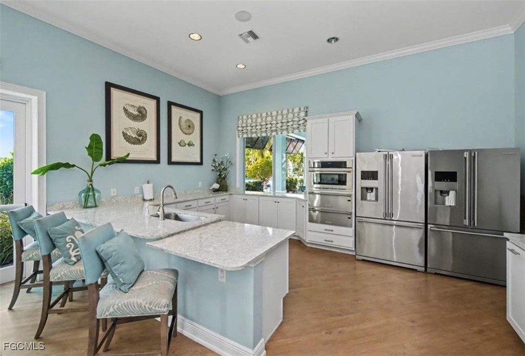 2613 Manzilla Lane Cape Coral, FL 33909 - Photo 38 of 42 a kitchen with stainless steel appliances granite countertop a sink and a refrigerator