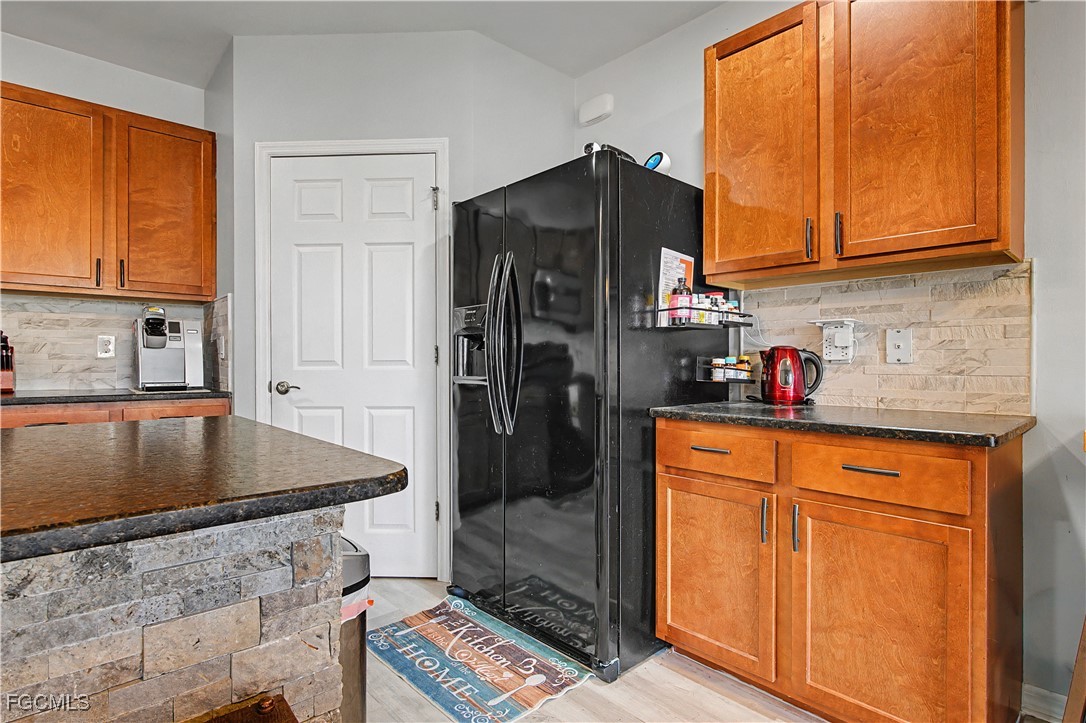2613 Manzilla Lane Cape Coral, FL 33909 - Photo 7 of 42 a kitchen with stainless steel appliances granite countertop a refrigerator a stove and a sink with wooden floor