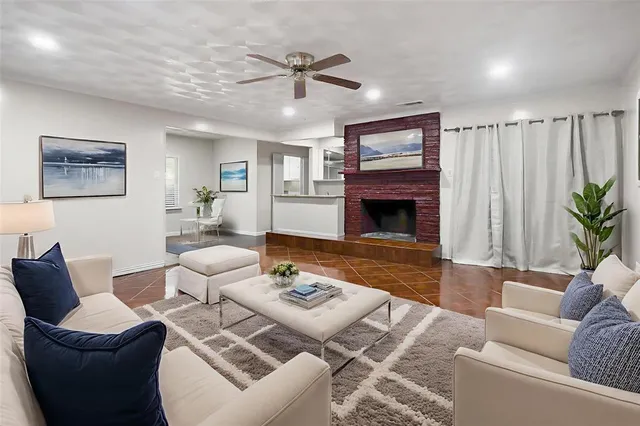 a living room with furniture a fireplace and a flat screen tv