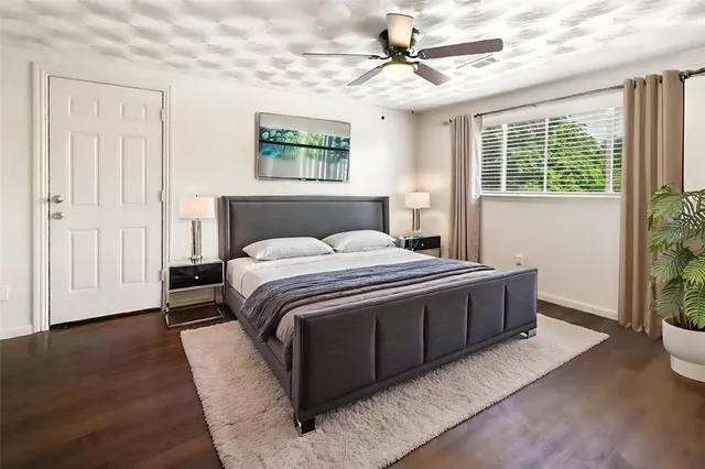 a bedroom with a large bed chandelier and a window
