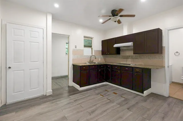 a kitchen with a stove and a wooden floor