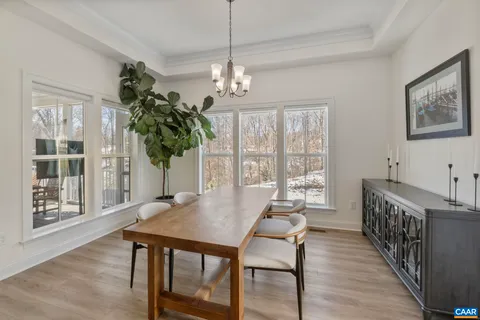 a kitchen with stainless steel appliances granite countertop a stove a refrigerator a sink dishwasher a dining table and chairs with wooden floor