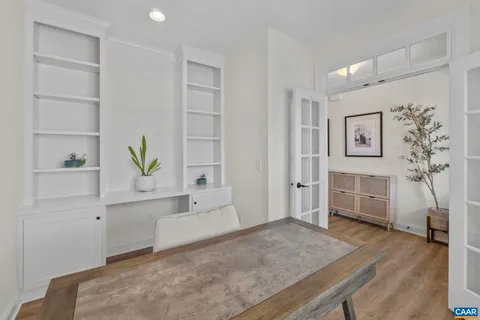 a view of a hallway with wooden floor and furniture