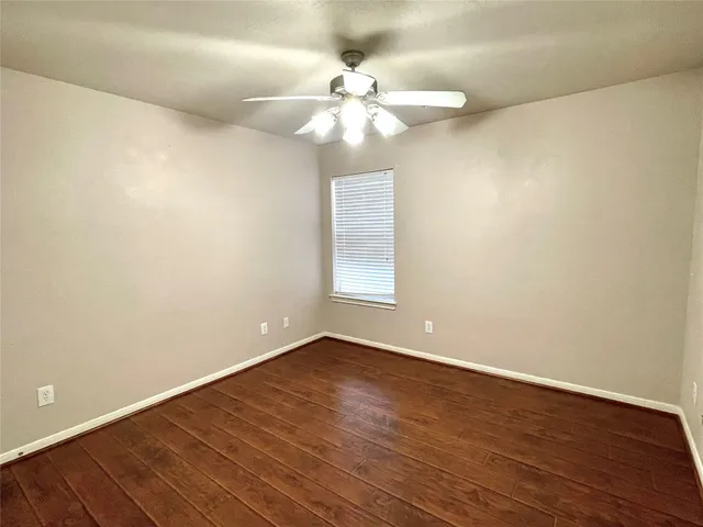 a view of an empty room with a chandelier fan