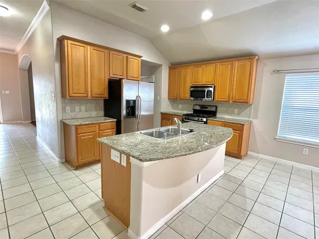 a kitchen with stainless steel appliances granite countertop a sink stove and refrigerator