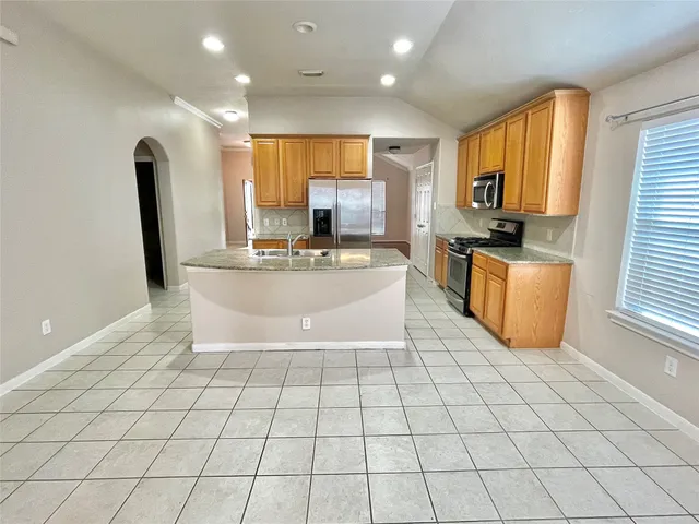 a kitchen with stainless steel appliances a sink a stove a microwave a counter top space and cabinets