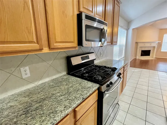 a kitchen with a sink a stove top oven and cabinetry