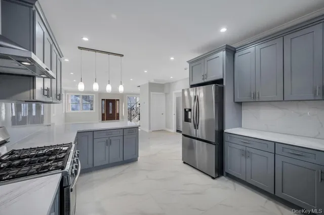 a kitchen with stainless steel appliances granite countertop a refrigerator a sink and wooden cabinets