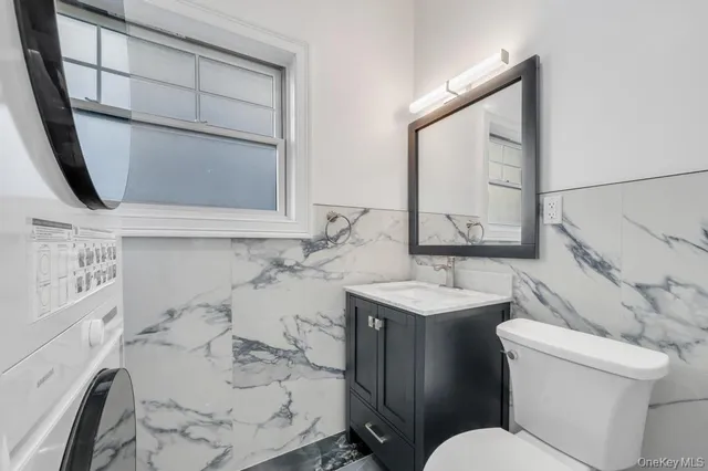 a bathroom with a sink toilet vanity and mirror