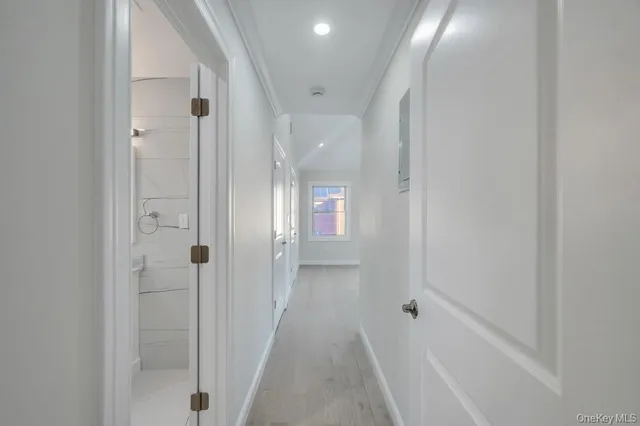 a view of a hallway with wooden floor and closet area