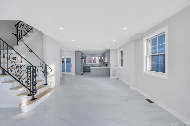 a view of an empty room with stairs and a window