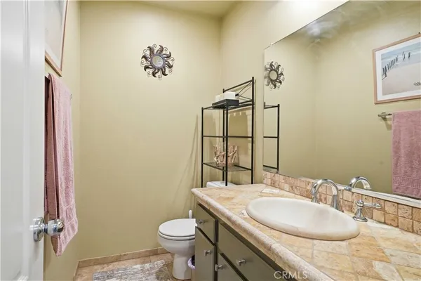 a bathroom with a granite countertop sink toilet and a mirror