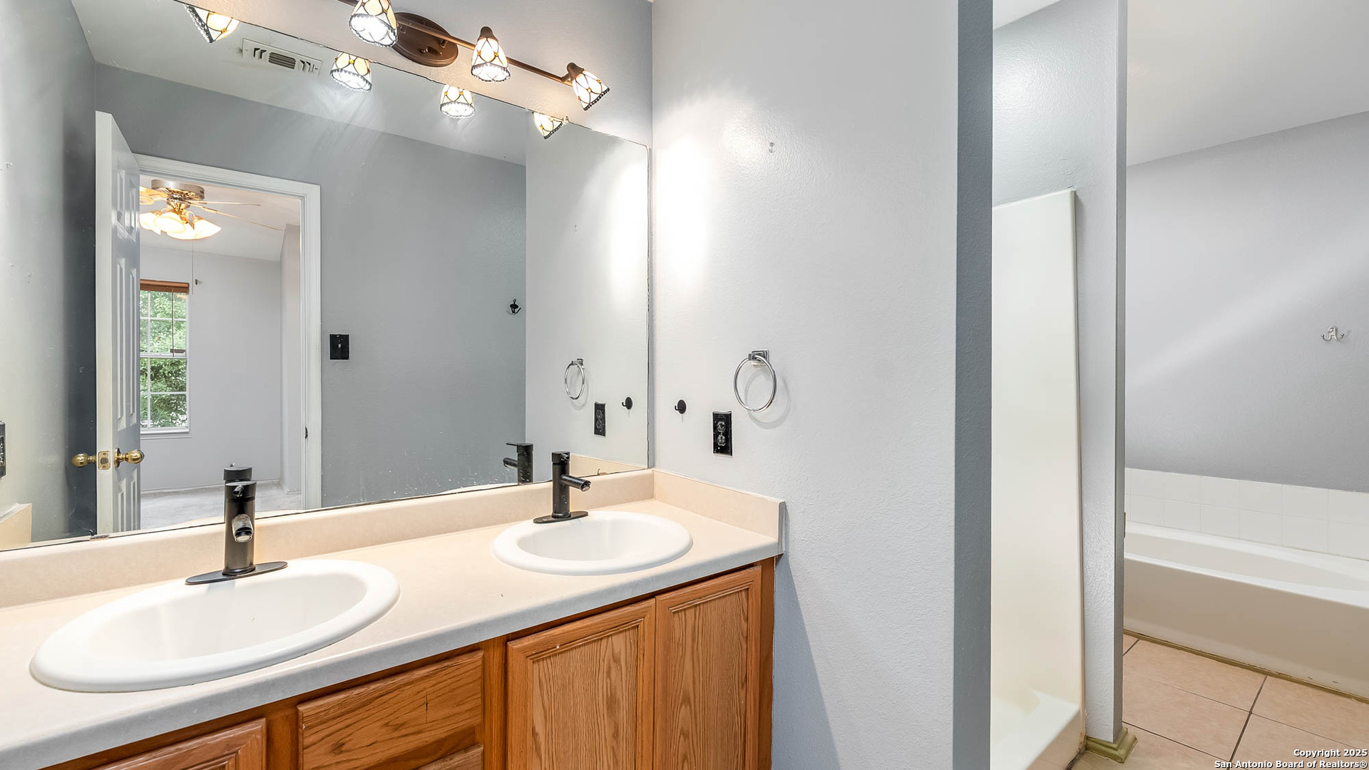 9406 San Fidel Rio San Antonio, TX 78245 - Photo 10 of 21 a bathroom with a sink double vanity and a mirror