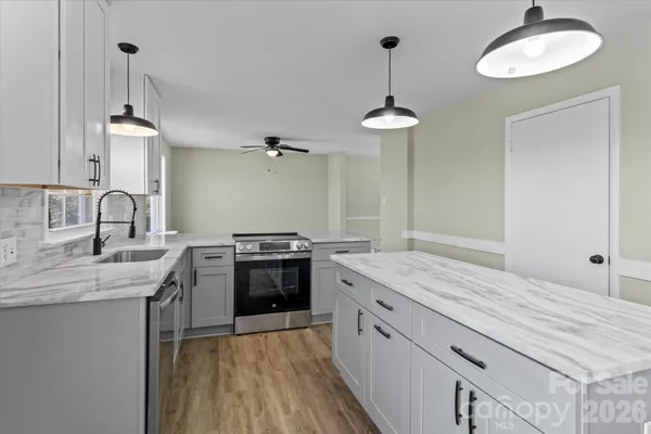 a kitchen with stainless steel appliances granite countertop a sink stove and refrigerator
