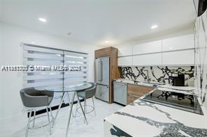 455 Northeast 210th Terrace Miami, FL 33179 - Photo 9 of 25 a kitchen with stainless steel appliances kitchen island granite countertop a sink and cabinets
