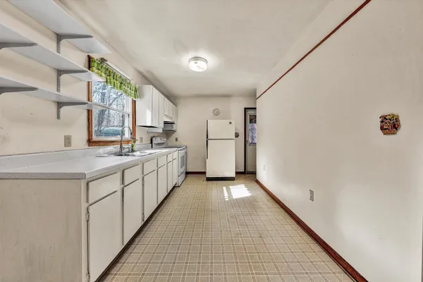 a kitchen with white cabinets and white appliances