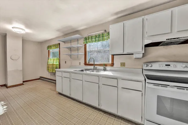 a kitchen with granite countertop white cabinets and white appliances
