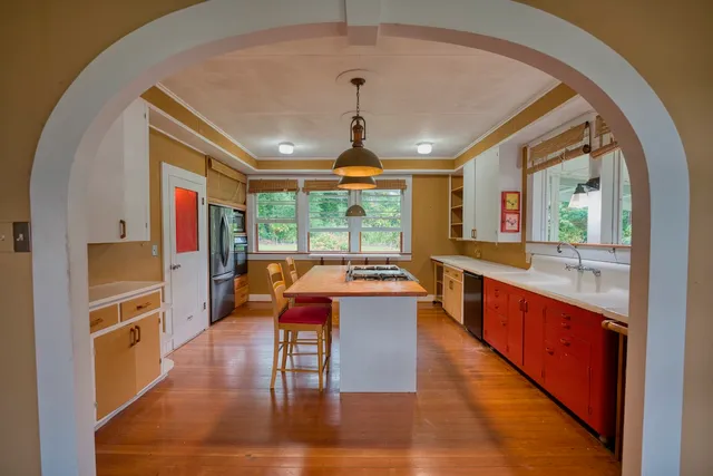 a large white kitchen with a large window