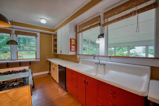 a kitchen with stainless steel appliances granite countertop a sink a stove and a wooden floor