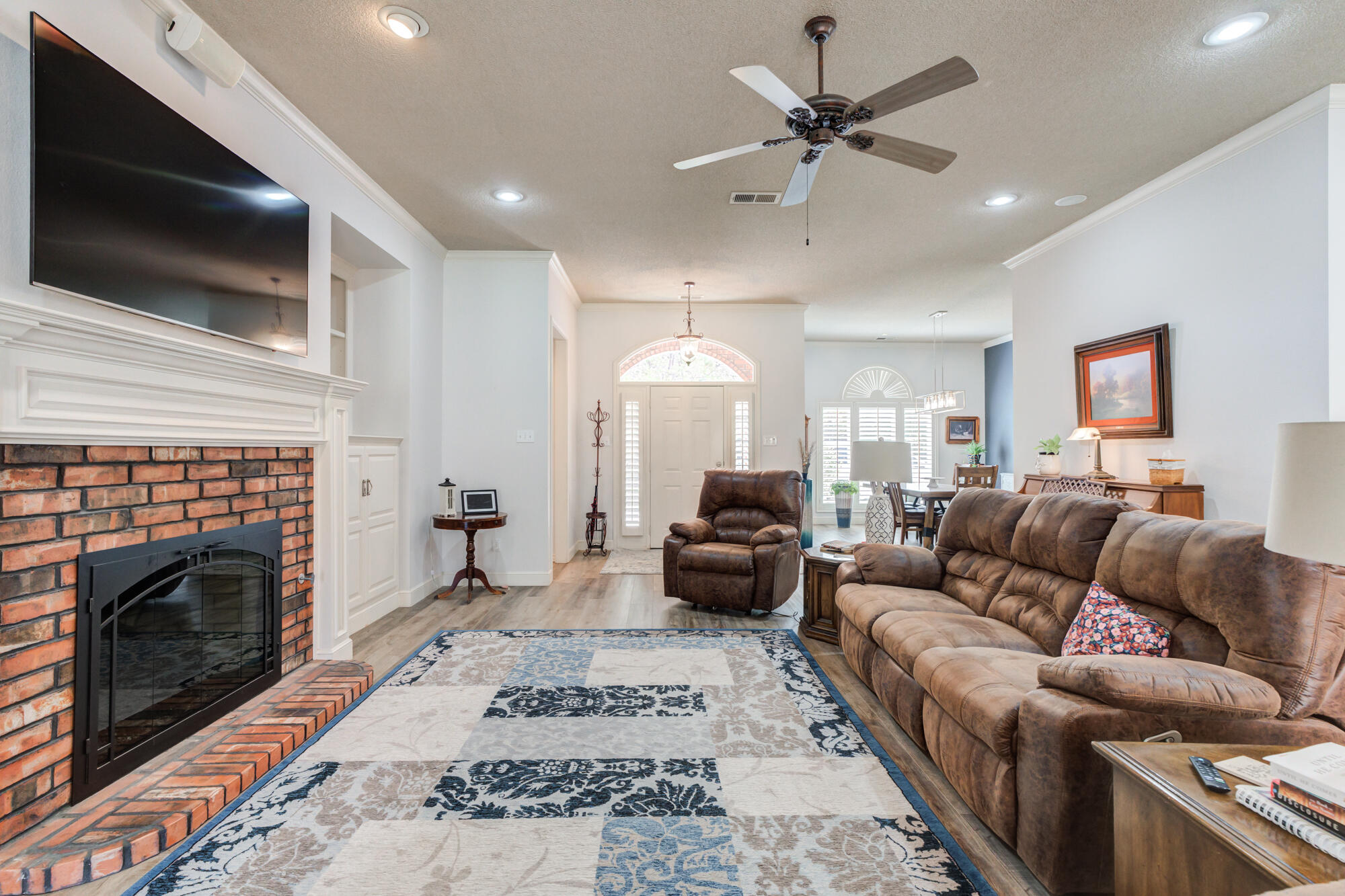 3522 156th Street Lubbock, TX 79423 - Photo 19 of 75 a living room with furniture a flat screen tv and a fireplace