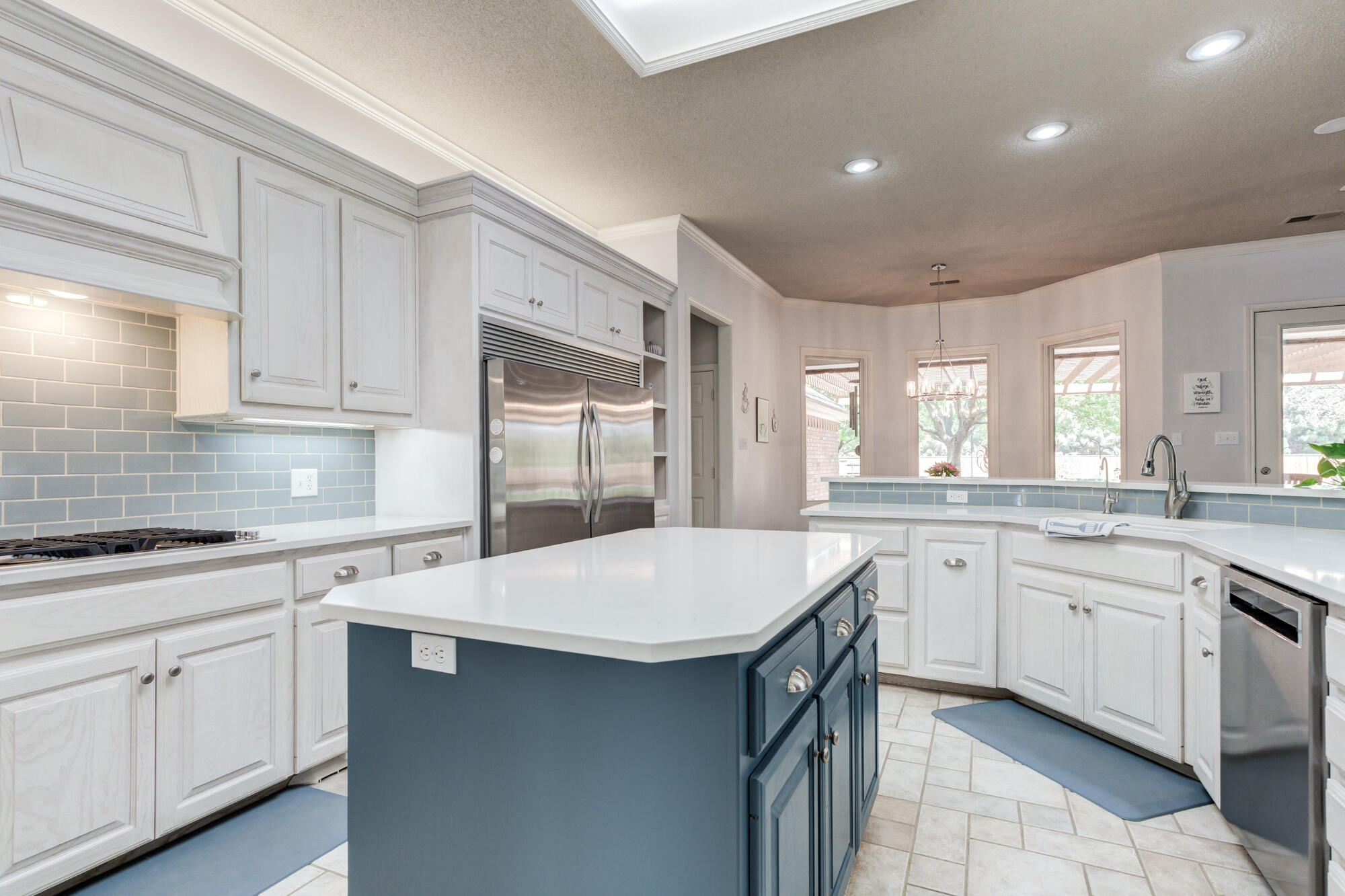 3522 156th Street Lubbock, TX 79423 - Photo 30 of 75 a kitchen with a sink dishwasher a stove and white cabinets