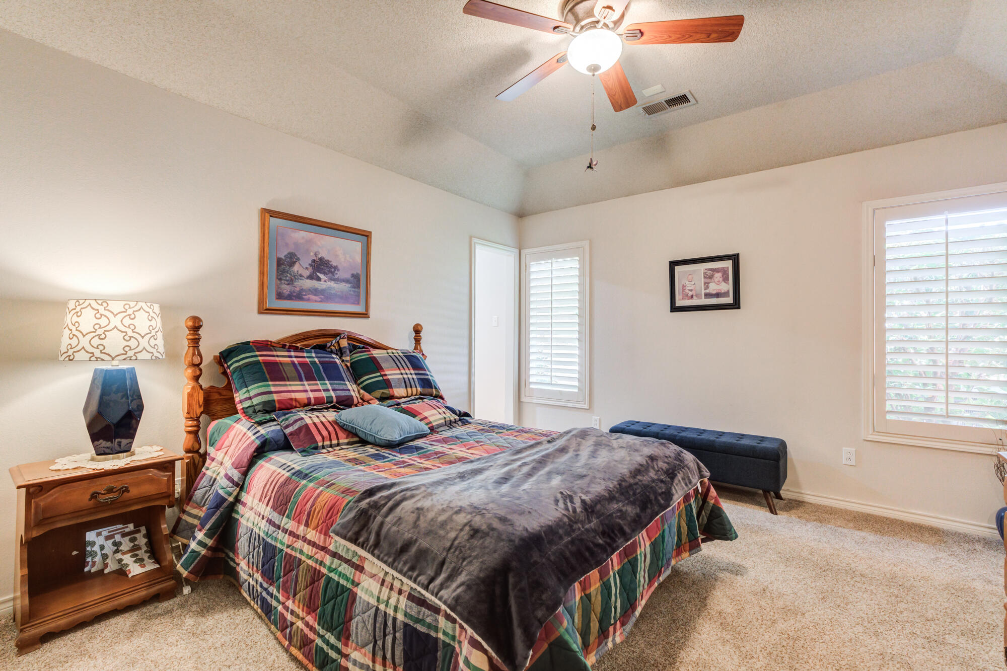 3522 156th Street Lubbock, TX 79423 - Photo 49 of 75 a bedroom with a bed a lamp and a chandelier