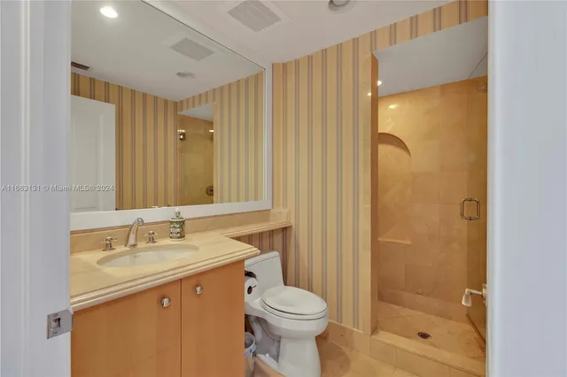 a bathroom with a granite countertop sink toilet and shower