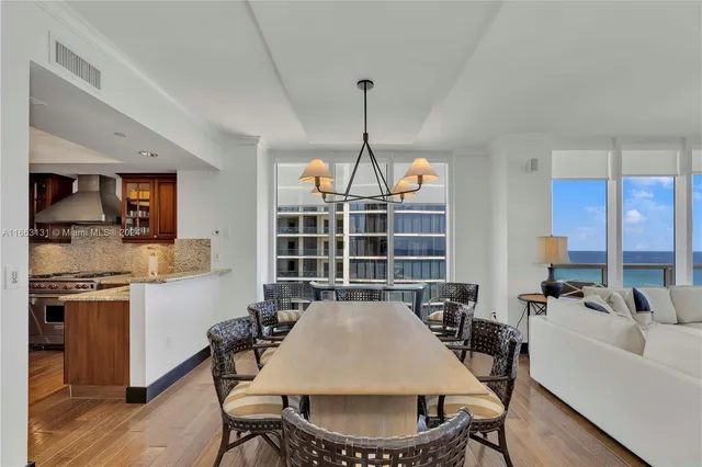a view of a dining room with furniture a chandelier and wooden floor