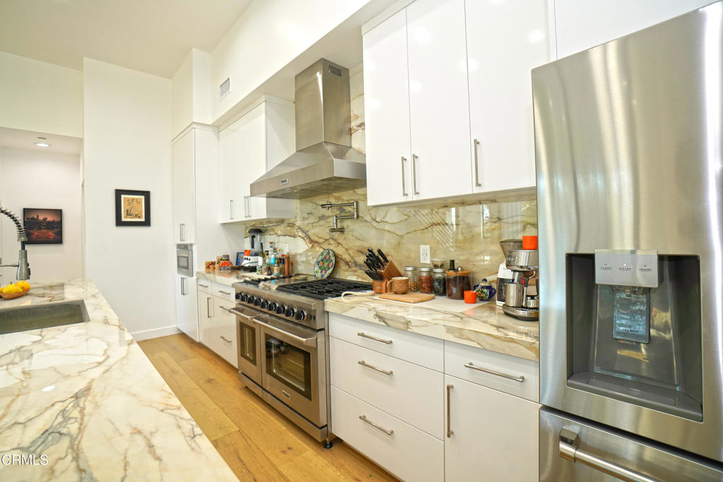 6565 Pickwick Street Los Angeles, CA 90042 - Photo 13 of 41 a kitchen with stainless steel appliances a stove a sink and white cabinets