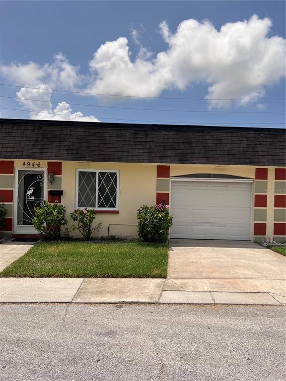 4946 Allner Street New Port Richey, FL 34652 - Photo 1 of 1 a front view of a house with a garden and garage