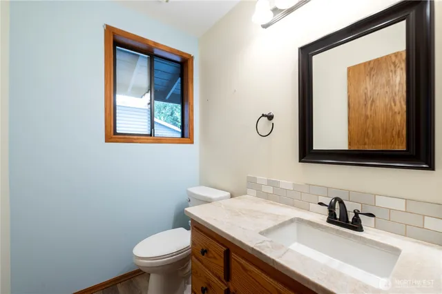 a bathroom with a toilet sink and mirror