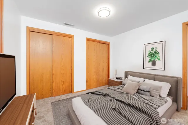 a bedroom with a bed and painting on the wall