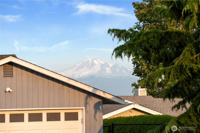 a front view of a house with a yard and potted plants