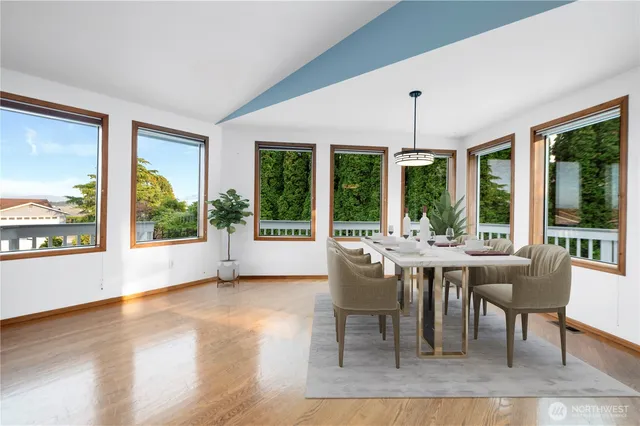 a dining room with wooden floor a chandelier a glass table and chairs