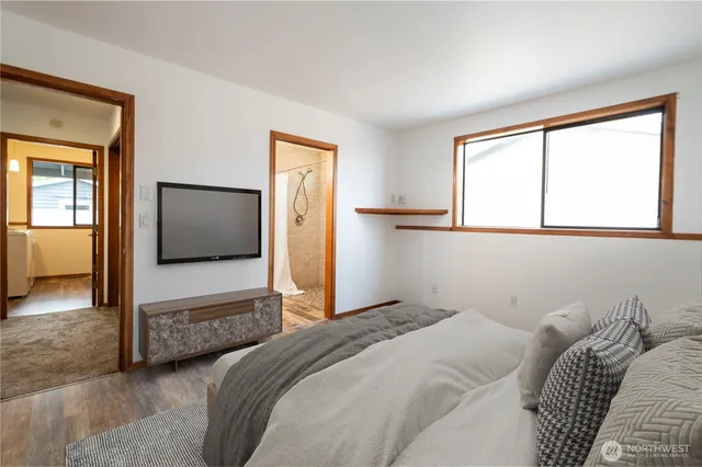 a bedroom with a large bed and a flat tv screen