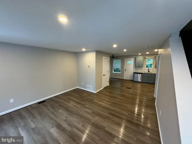 a view of empty room with wooden floor