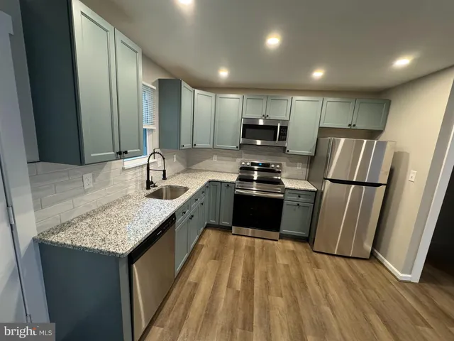 a kitchen with sink a refrigerator and chairs