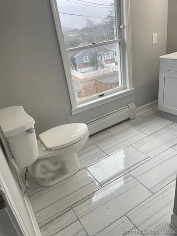 a white toilet sitting next to a window