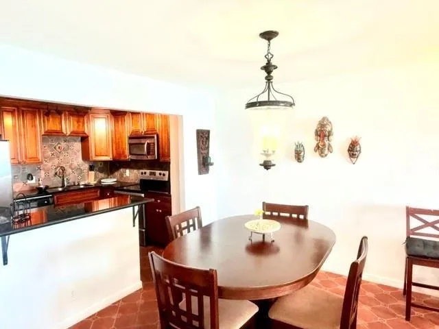 a kitchen with a refrigerator a stove and a sink with wooden floor