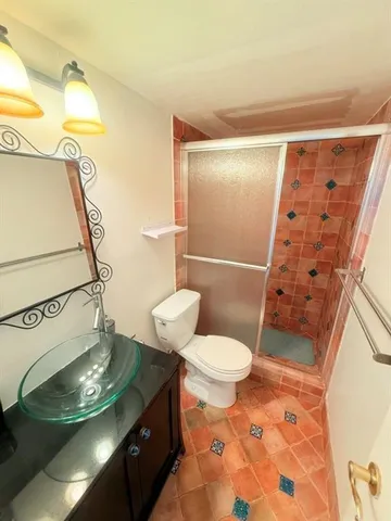 a bathroom with a granite countertop sink toilet and shower