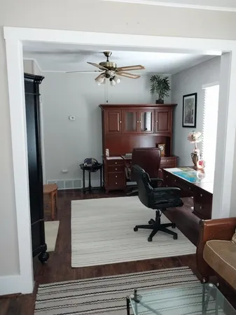 a view of a workspace with furniture and a window