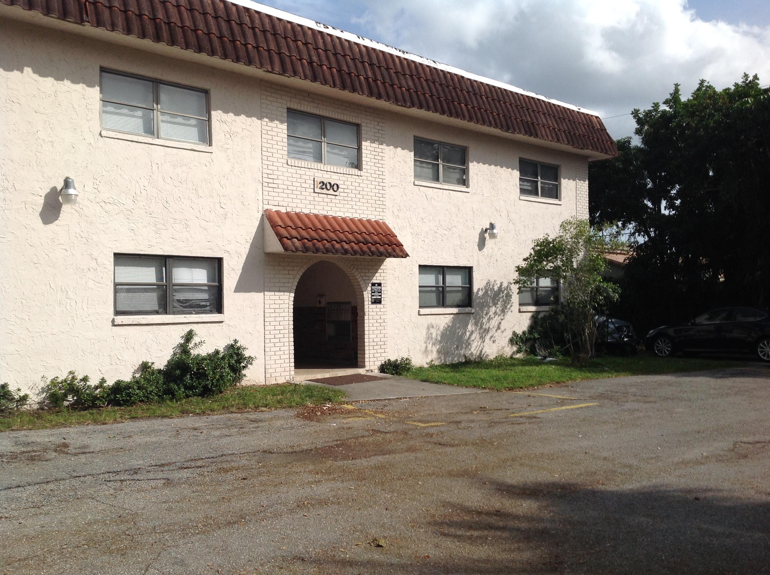1195 Northwest 16th Avenue, Unit 10 Boca Raton, FL 33486 - Photo 12 of 13 a view of a house with a yard and garage