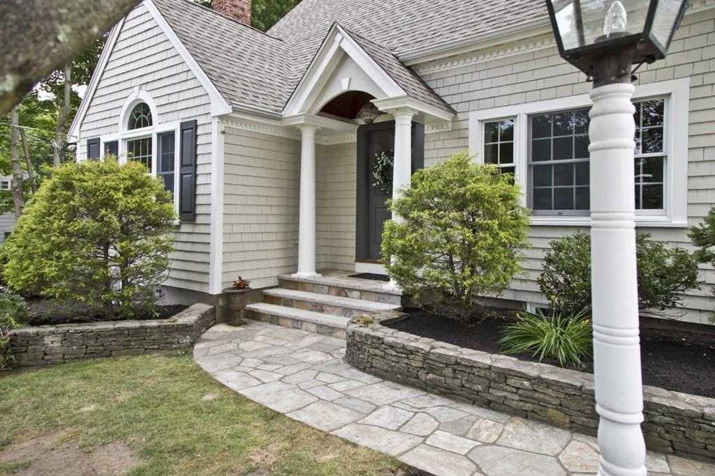 10 Bainbridge Road Reading, MA 01867 - Photo 3 of 3 a view of a white house next to a yard with potted plants