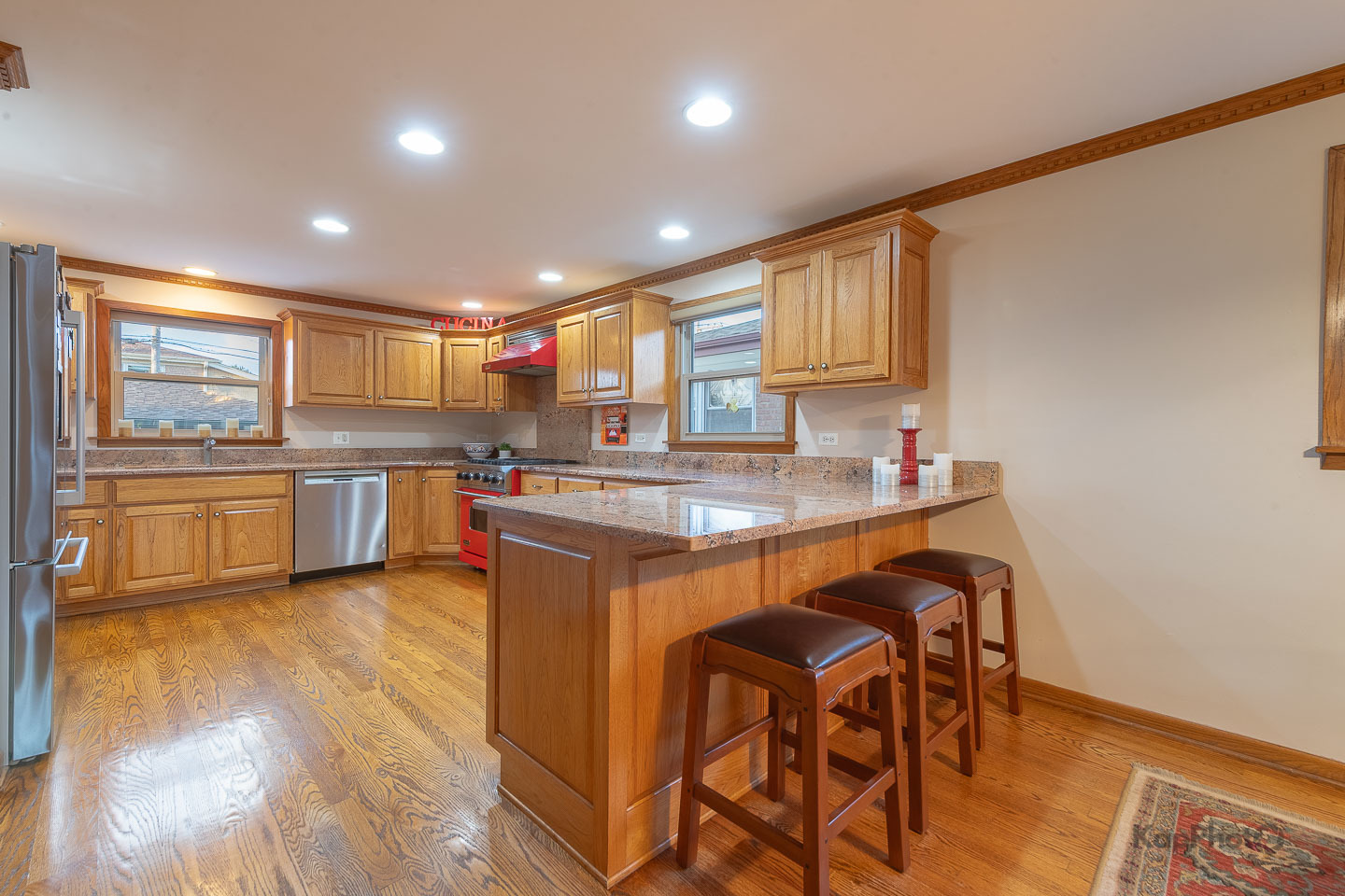 604 West 43rd Street Chicago, IL 60609 - Photo 8 of 30 a kitchen with stainless steel appliances granite countertop a sink a stove a refrigerator cabinets and a dining table with wooden floor